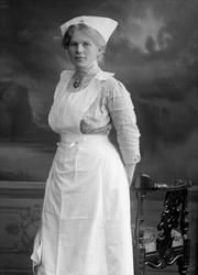 Portrett, jente i husstellsuniform?. Frøken Dora Nielsen.