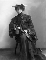 Portrett, sittende kvinne i svarte ytterklær. Frøken M Stari