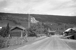 Gudbrandsdalen, juli 1968. Vei, bil og gårder. Flagg på halv