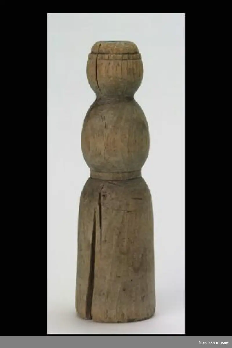 Inventering Sesam 1996-1999:
H 19 cm
Diam 5 cm
Docka av svarvat trä, markerad midja, hals och hatt, omålad.
Leif Wallin 1996