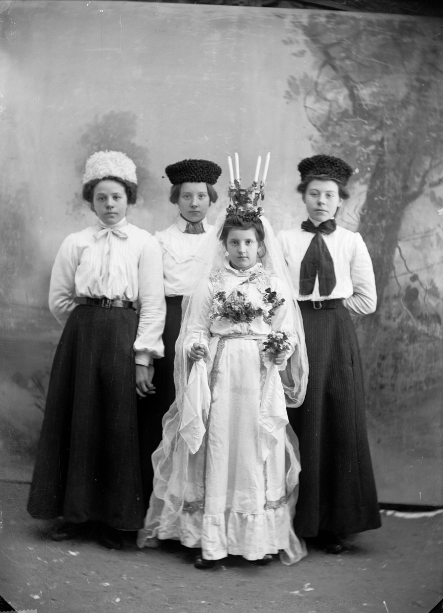 Lucia i Lima 1906. Berta Olsson (Lassar-Olle) från Lassargården i Heden är klädd till Lussebrud. Bakom henne står Jenny Martinsson, Elin Johansson och Olga Johansson från Sörbäcken.