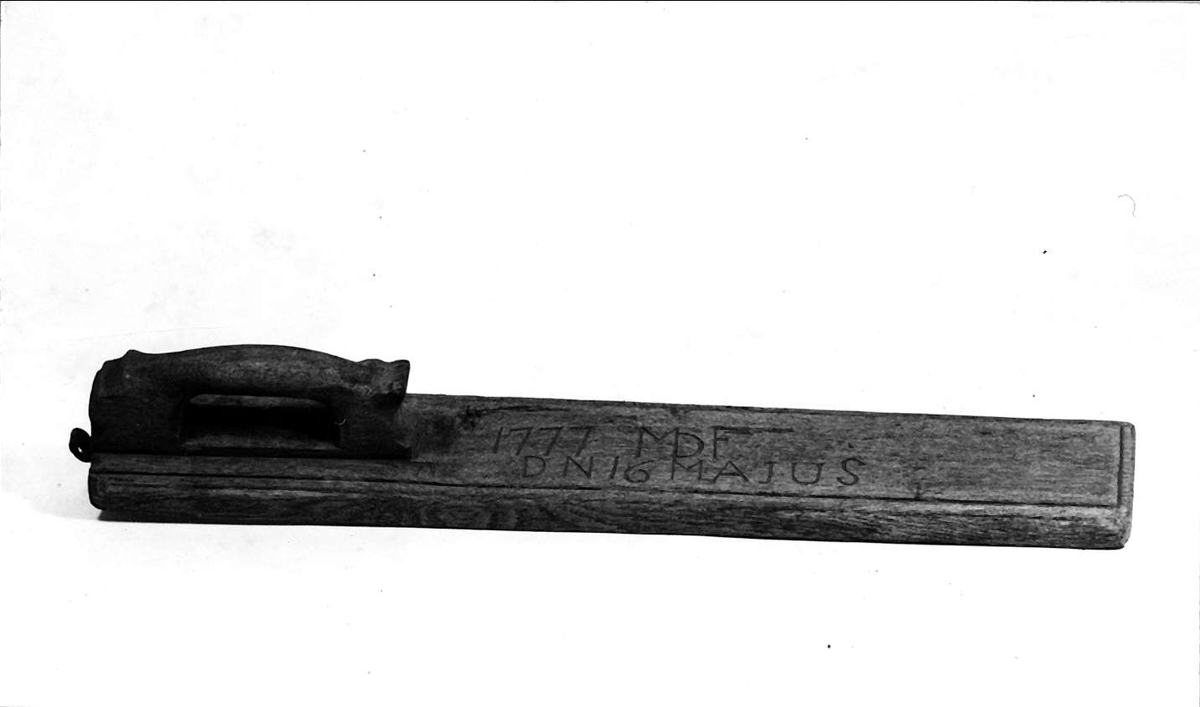 Mangelbräde av trä. Inristat: 1777 MDF DN 16 MAJUS. Läderögla för upphängning. Handtag och bräda i ett stycke.
