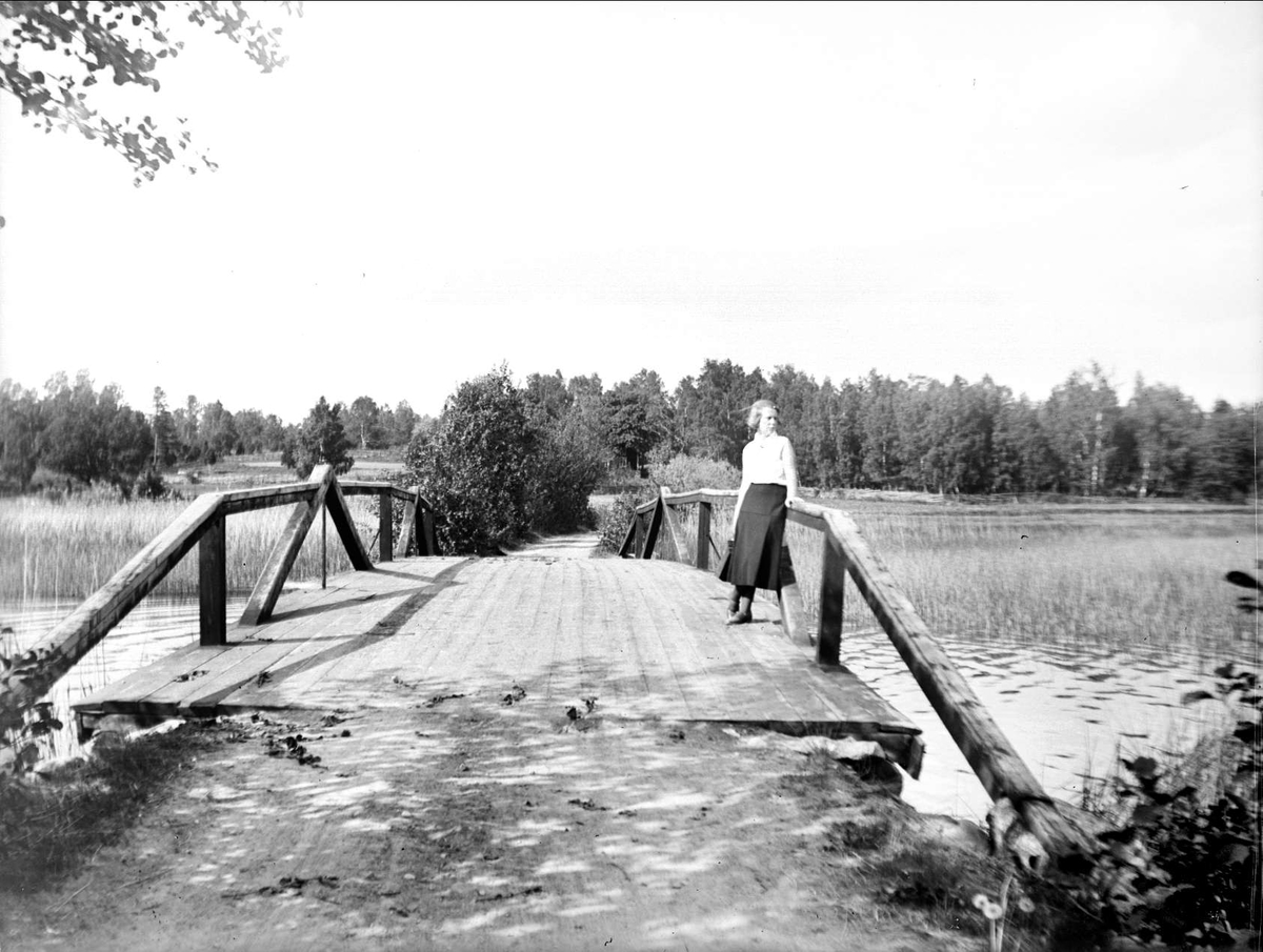 Kvinna på bro, vid Södersjön, Almunge socken, Uppland juni 1933