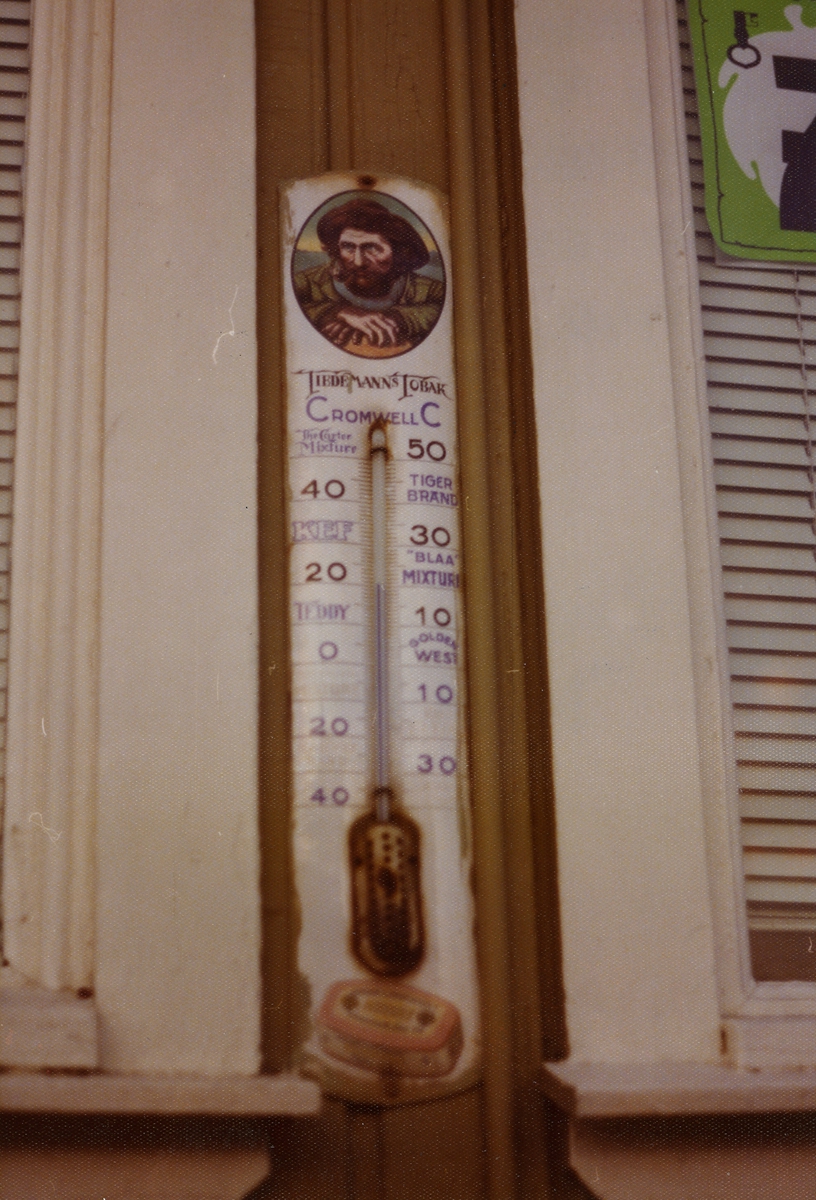 Termometer fra Tiedemann på fasaden til kolonialforretning i Drøbak.