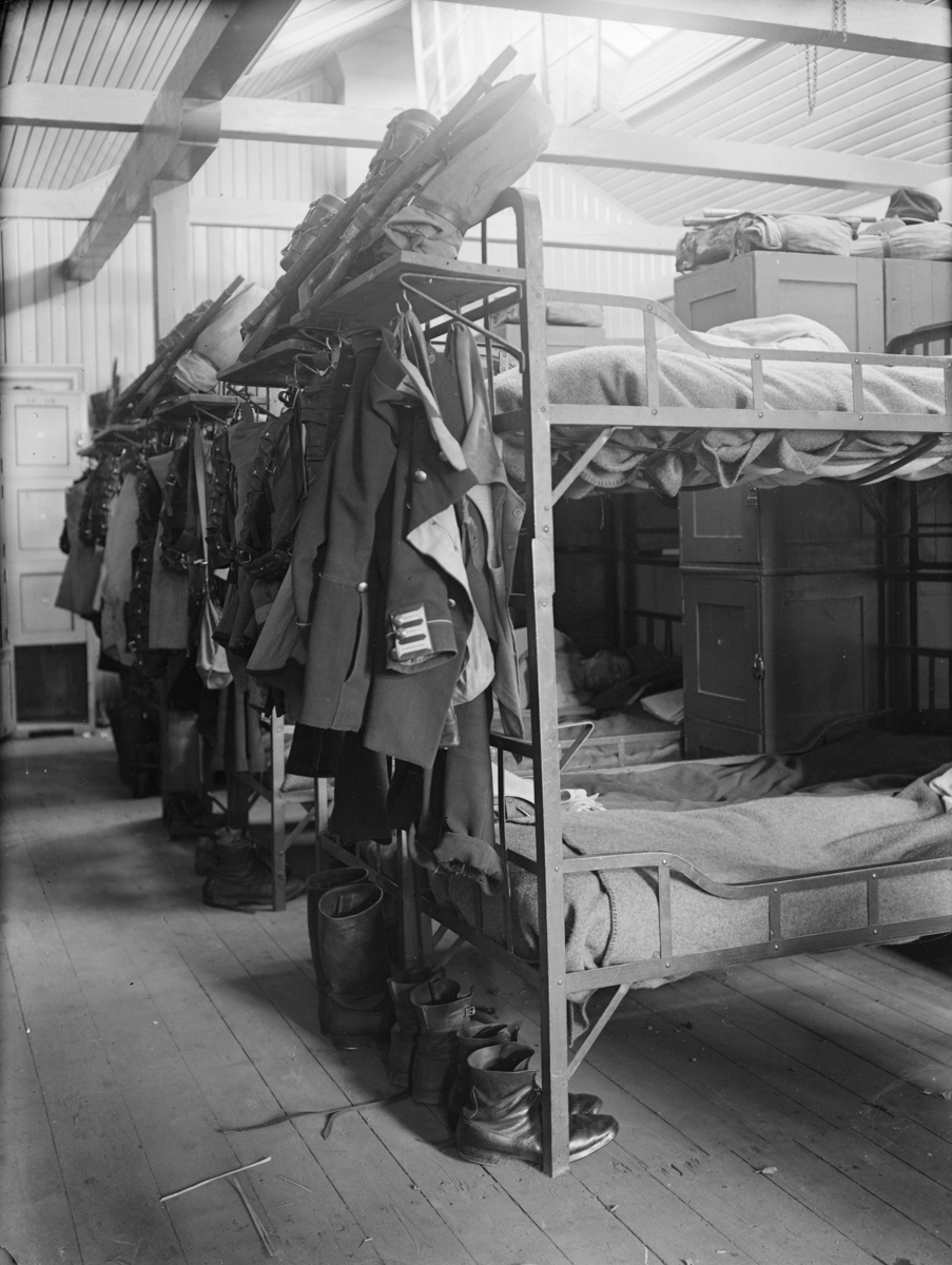 Interiör av logement på I 4 regemente på lägerområdet på Malmen. Sängar, kläder och utrustning.
