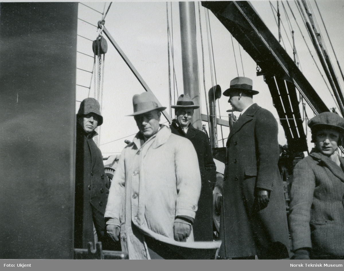 Fire menn og et barn på dekk på hvalfangstskipet D/S Hav (omdøpt til Hvalur 4 i 1963), B/N 460 under prøvetur i Oslofjorden. Skipet ble levert av Akers mek. Verksted i 1931 til A/S Polhavet ved Granøe & Fuhr, Tønsberg.