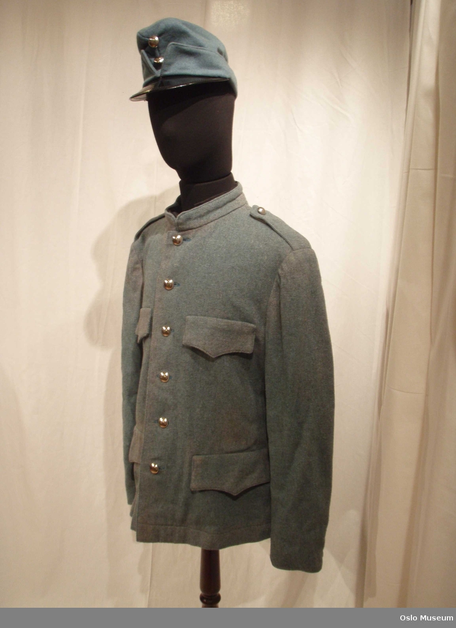 Uniformslue og jakke i blått ullstoff med messingknapper.