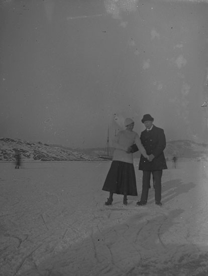 Enl. text i blå bok: "Par med skridskor på en fjord."