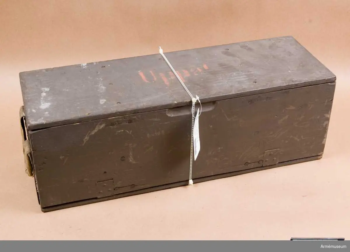 Grupp E V.
Arbetsmodell å 7 cm patronlåda med fästanordning för de lösa filtskivorna.
Enligt Artilleridepartementets skrivelse den 17 januari 1913.
Lådan är tom.