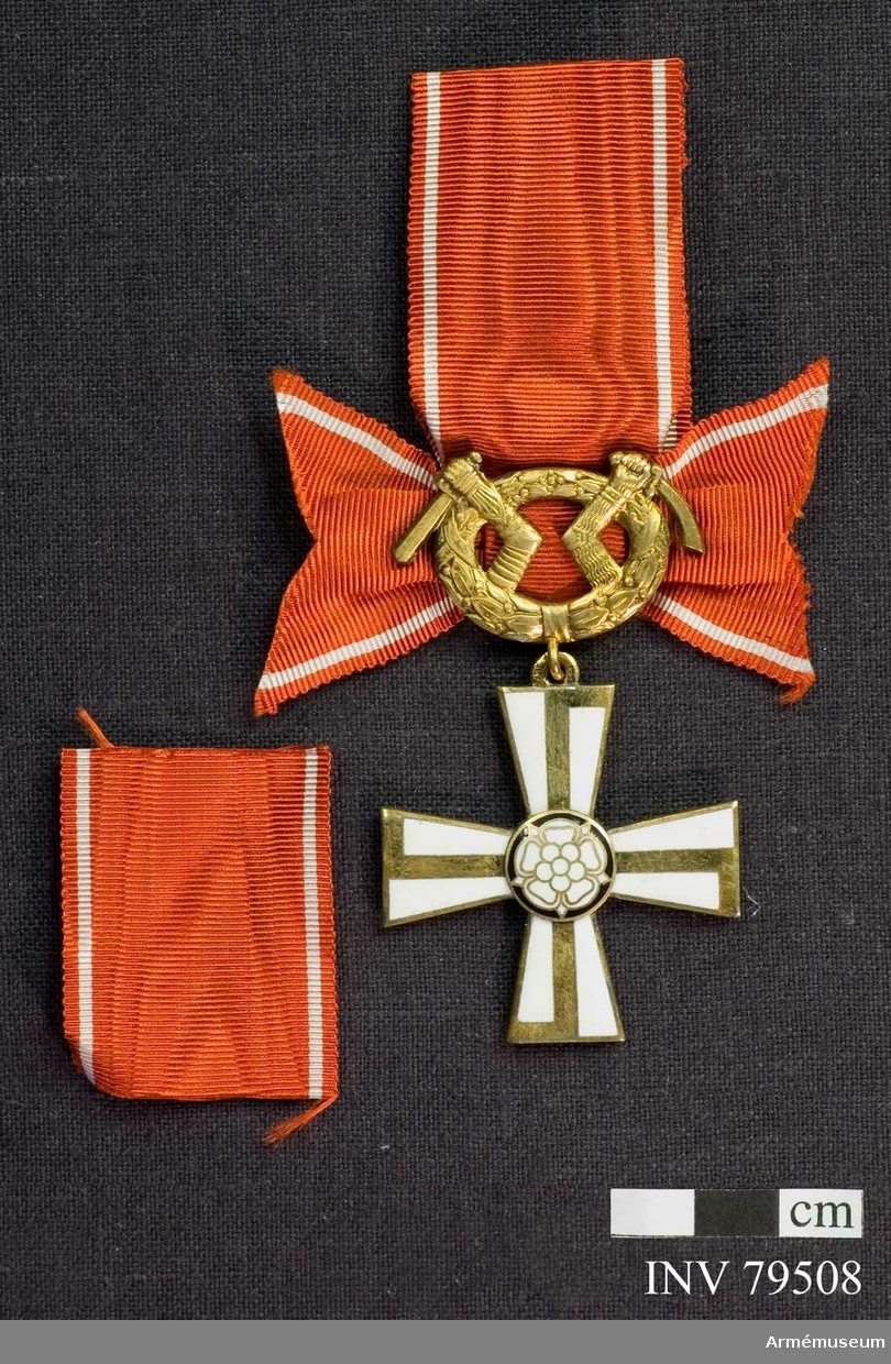 Ordenskors med lagerkrans med Karelens vapen. Bandrosett, röd med vita ränder. 
För riddare, militär, II.klass av finska frihetskorset.