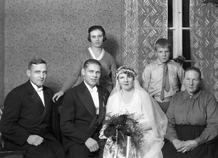 Uppgift enligt fotografen: "Uddevalla. Gruppfoto bröllop. Hans Karlsson, Hemmiljö."