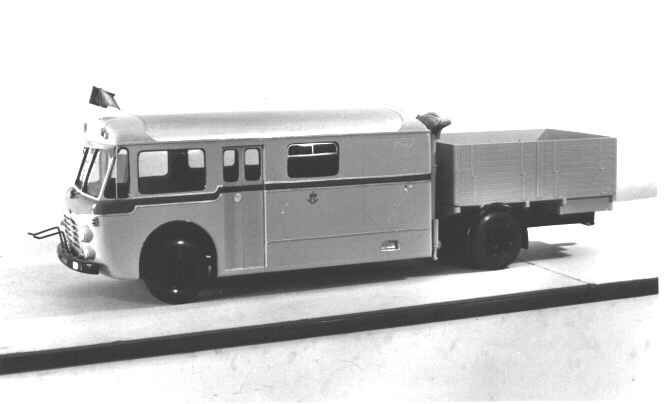 Modell till bildiligens av den typ som populärt kallades "Skvader" eftersom den är en kombinerad buss och lastbil med flak. Modellen består av gult karosseri (längd 590 mm) i trä med blå bård, svart kofångare, svarta hjul, plastfönster. Inredning saknas.
Gul flakvagn (längd 340 mm). Hävanordning mellan karosseri och
flak.

Förebilden till modellen har identitetsnummer K 114, inom
Storumanområdet, med chassi av märket Scania-Vabis, typ 7558,
årsmodell 1959.Hjulbas 575 mm, axeltryck 8008 kg. Antal passagerare 13, högstatillåtna godsvikt 3061 kg, varav 3180 på flaket.
Drivmedeldieselolja, lastapparat och färdskrivare av typen Kientzle.
Kaross med passagerare- och bagageutrymmen samt flak och lämmar, fabrikat Svenska Karosseri Verkstäderna, Katrineholm.