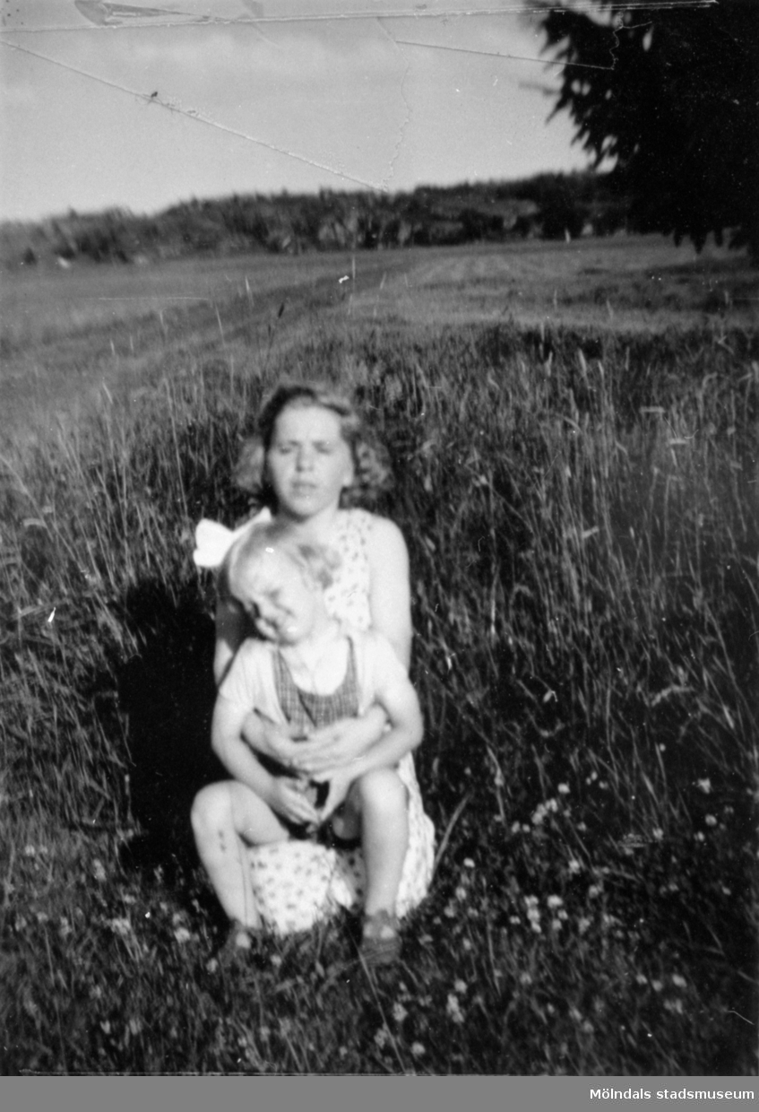 Inga-Lill Lipovsék 6 år, boende på Stretereds skolhem, troligtvis tillsammans med sin mamma på en sommaräng vid Stretereds skolhem, 1953. Ängen är där Sagåsens vårdavdelning byggdes.