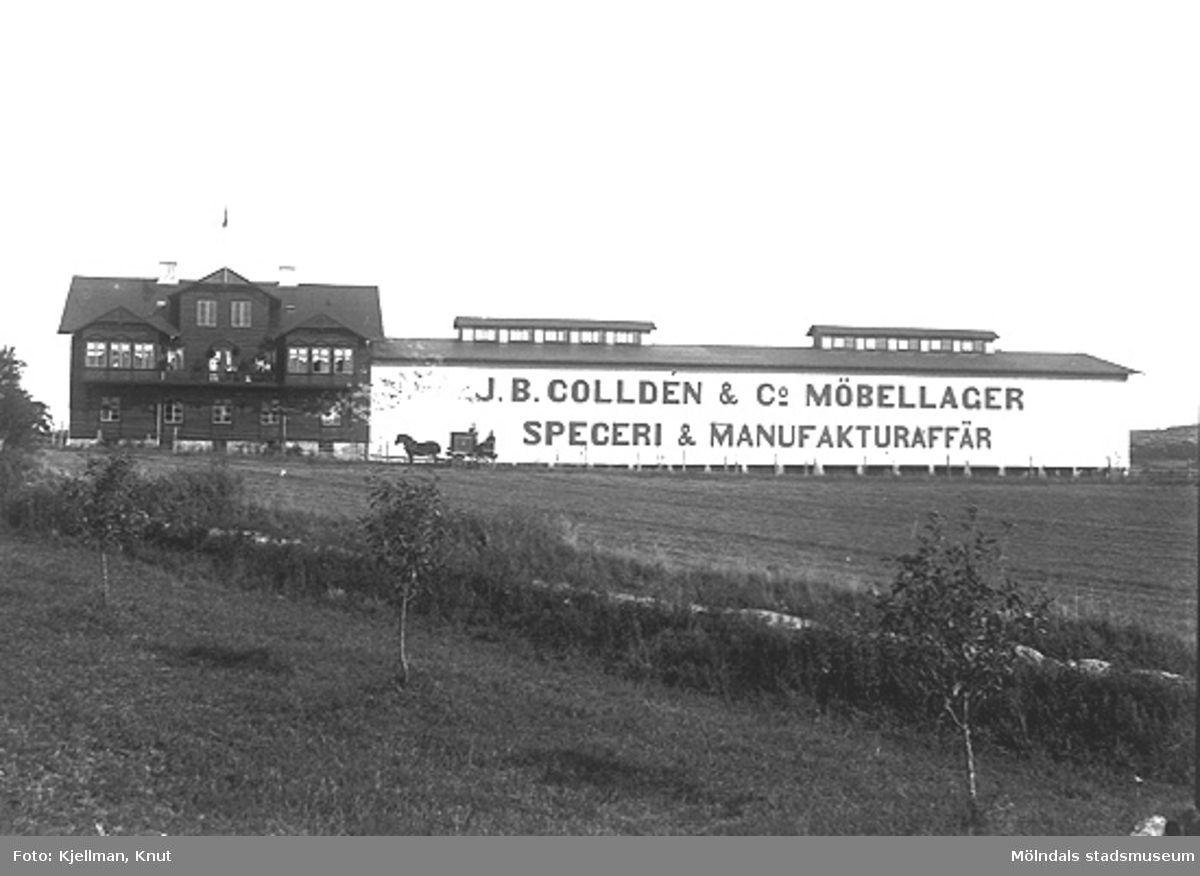 Reklam i kolossalformat, utanför Colldéns i Almås, som riktar sig mot järnvägen. 
J.B. Colldén & Co Möbellager Speceri & Manufakturaffär var på sin tid en av Göteborgs stora möbelhandlare.