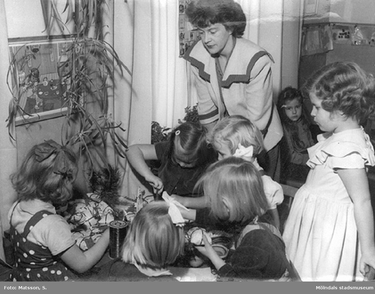 Margit och förskolebarnen slår in julklappar på Hertagårdens barnträdgård i Borås, år 1952.
