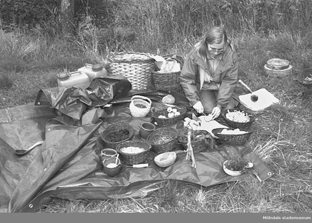 Familjesöndag vid Börjesgården, 1994-05-15. En kvinna gör en smörgås på ett uppdukat smörgåsbord som är placerat på marken.