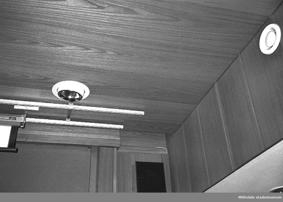 Mölndals stadshus, juni 1994. Del av vägg och tak klädda i ek-panel i ett sammanträdesrum. I taket sitter skenor samt en lampa. På väggen finns en ventil.