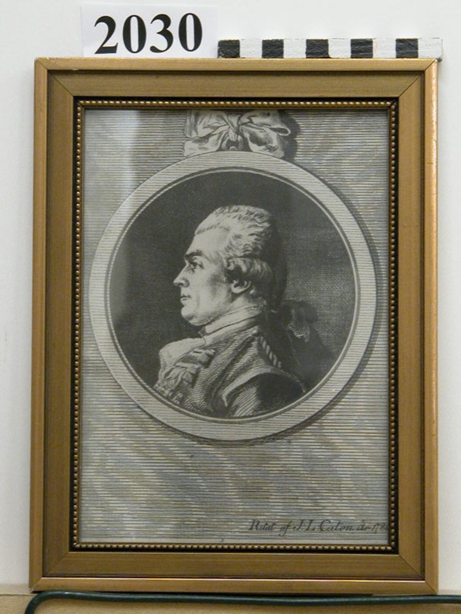 Etsning, fotoreproduktion av viceamiral friherre Otto Henrik Nordenskjöld, ritad av J.L. Cason, 1786. Porträttet utfört inom medalj med rosett på överkansten. Märkning: Ritat af J. L. Caton år 1786. Inom glas och ram, förgylld.