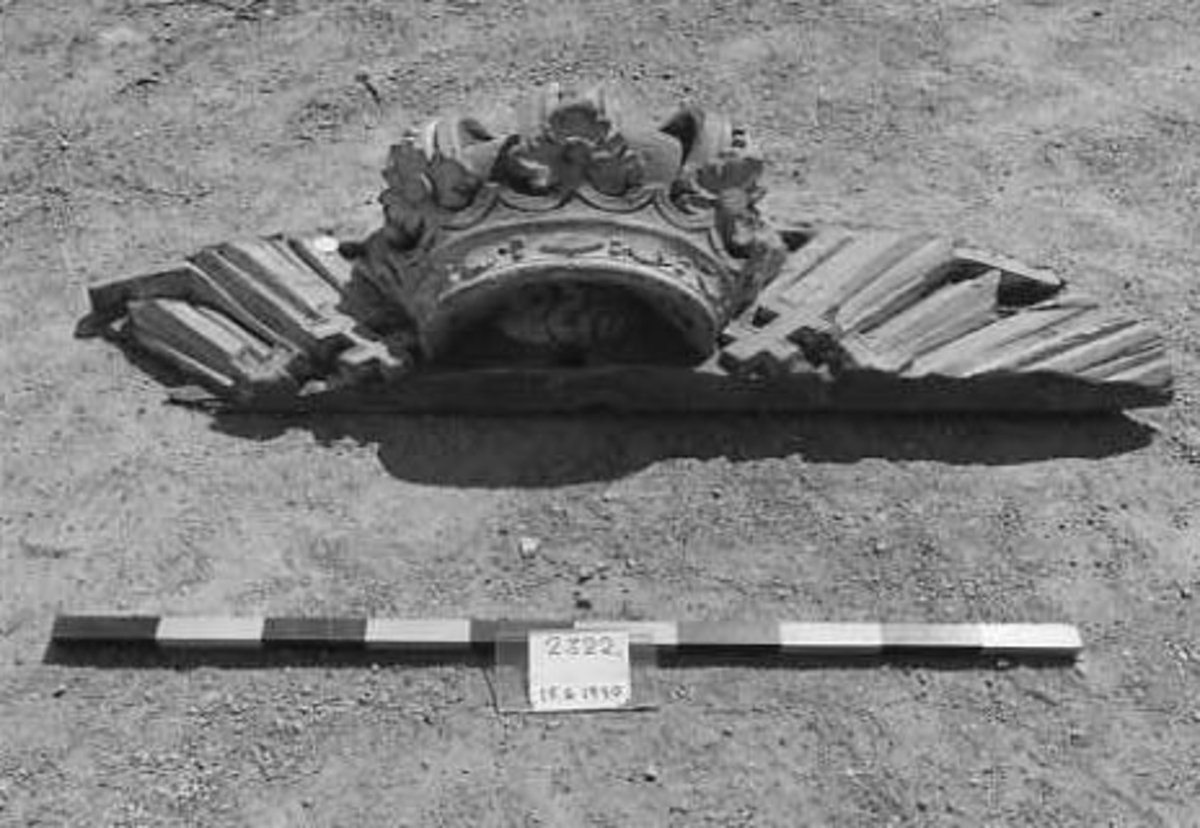 Fragment, kunglig krona fästad på resterna av ett strålknippe, varå det finns rester av  serafimerkedja.