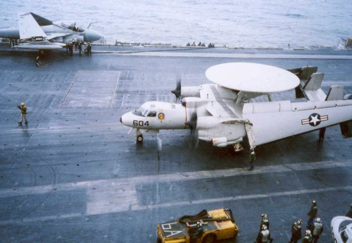 Amerikansk fly av typen E-2C Hawkeye midt på bildet og bak sees et amerikansk fly av typen A-6 Intruder. Begge flyene er ombord på Hangarskipet Eisenhower med nr. CVN 69, som er ute i Vestfjorden.