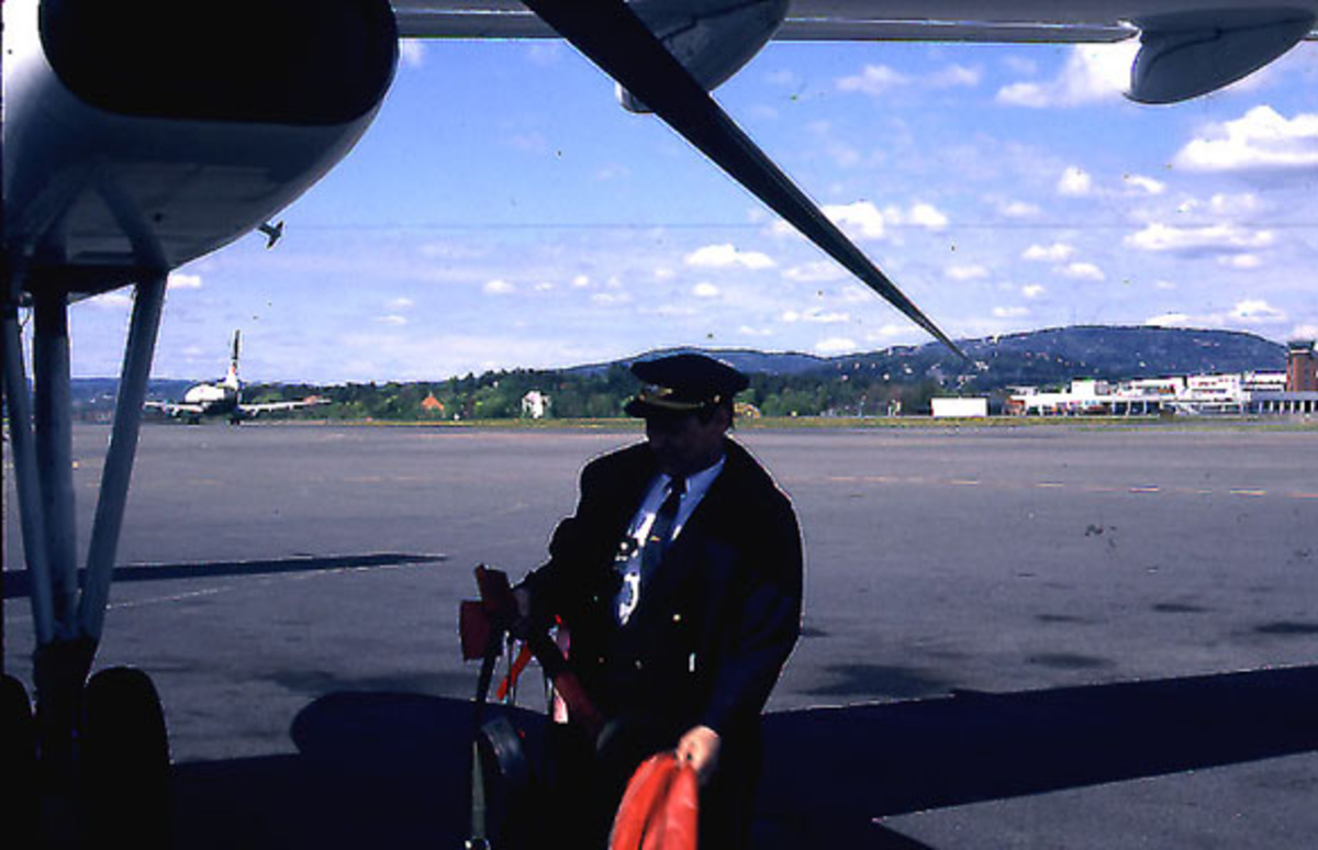 Lufthavn, fly, DHC-8-103, fra Widerøe. Detalj av en av motorene. En person i flyuniform ved flyet.