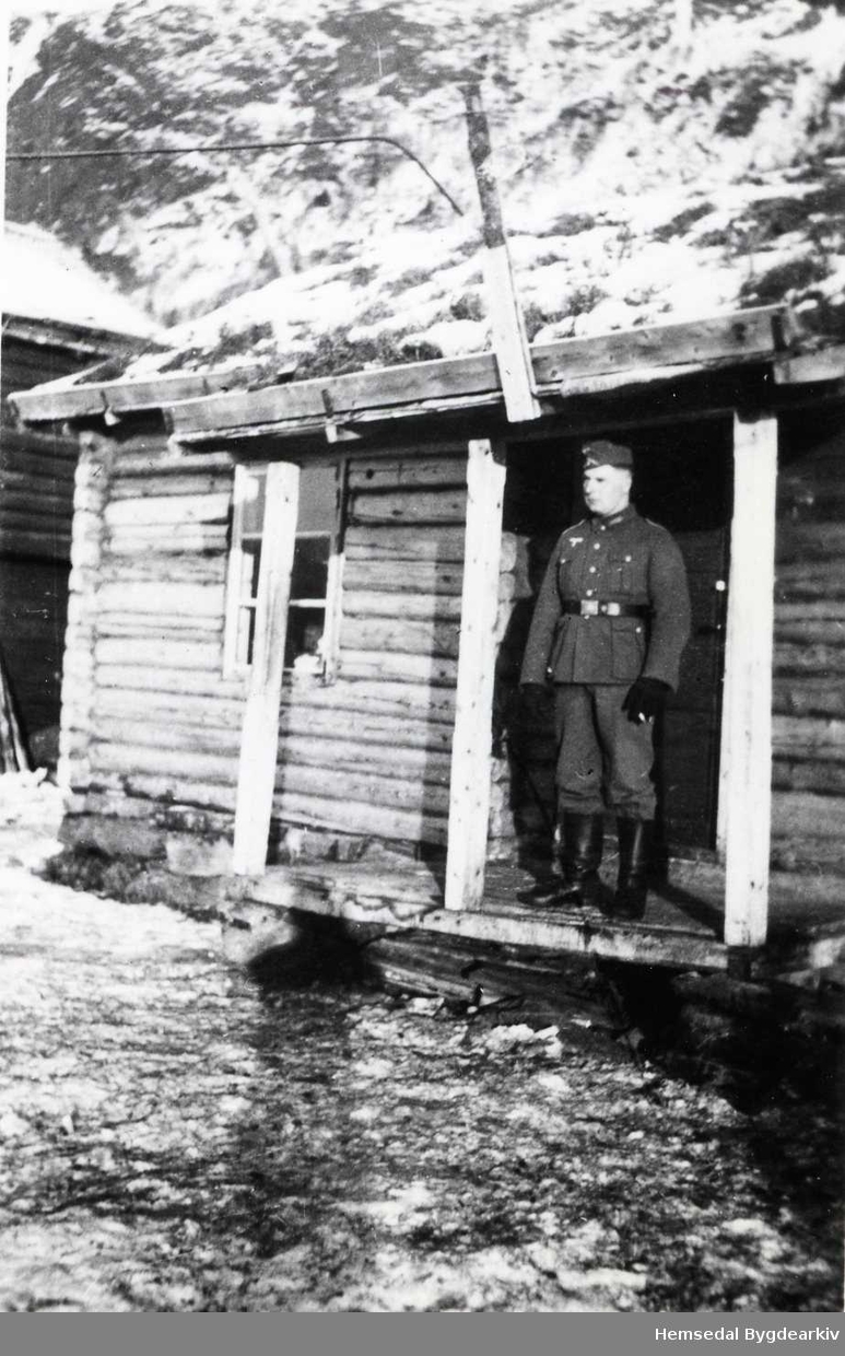 Tysk soldat  i 1941 på Ulsåk i Hemsedal. Før tyskarane fekk eigne brakker, budde dei i hus på gardane i bygda. Dette huset vart rive i ca. 1970.