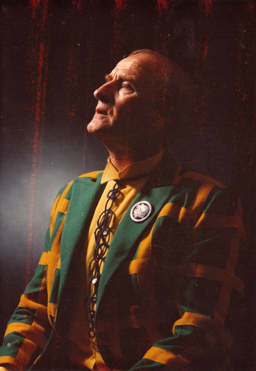 Portrett av Ludvig Eikaas med bobleslips og grøn og gul rutetete jakke. 3/4 profil