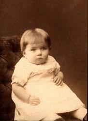 Portrett av Gunhilde Moe som barn i lys kjole med blonde, si