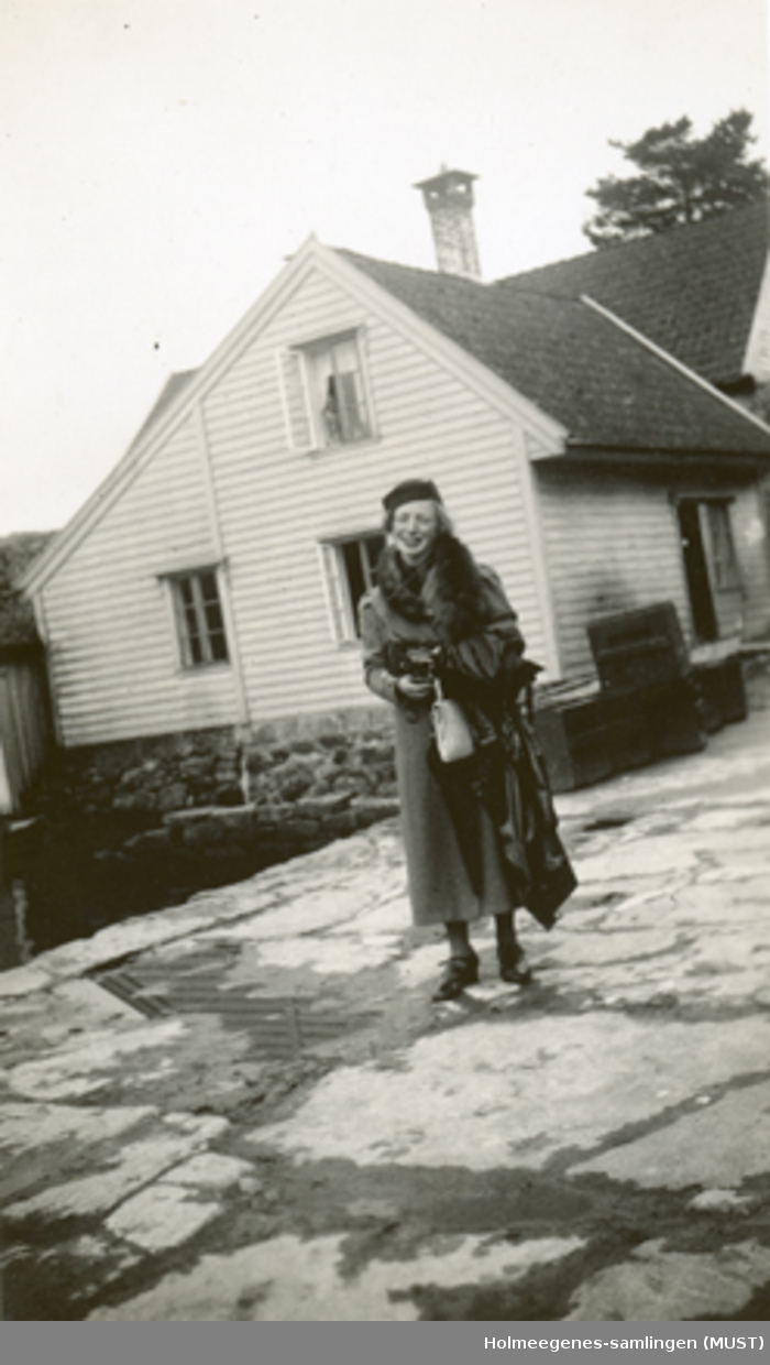 En ung kvinne foran et bolighus.
