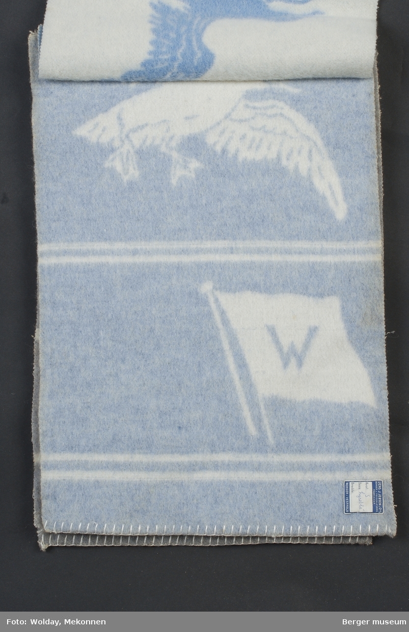 Ullteppe
Rederiflagg med bokstaven W for Wilhelmsen. Måkemønster i bunn