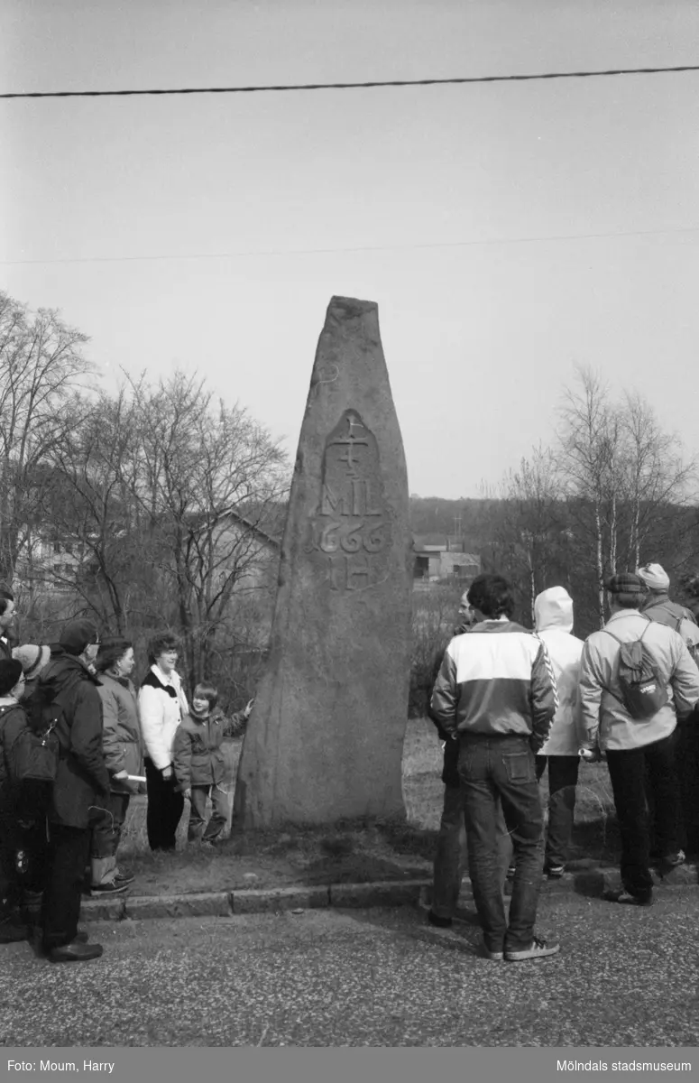 Lindome Hembygdsgille anordnar sockenvandring i Lindome, år 1983. En samling människor vid Brostenen i Annestorp.

För mer information om bilden se under tilläggsinformation.