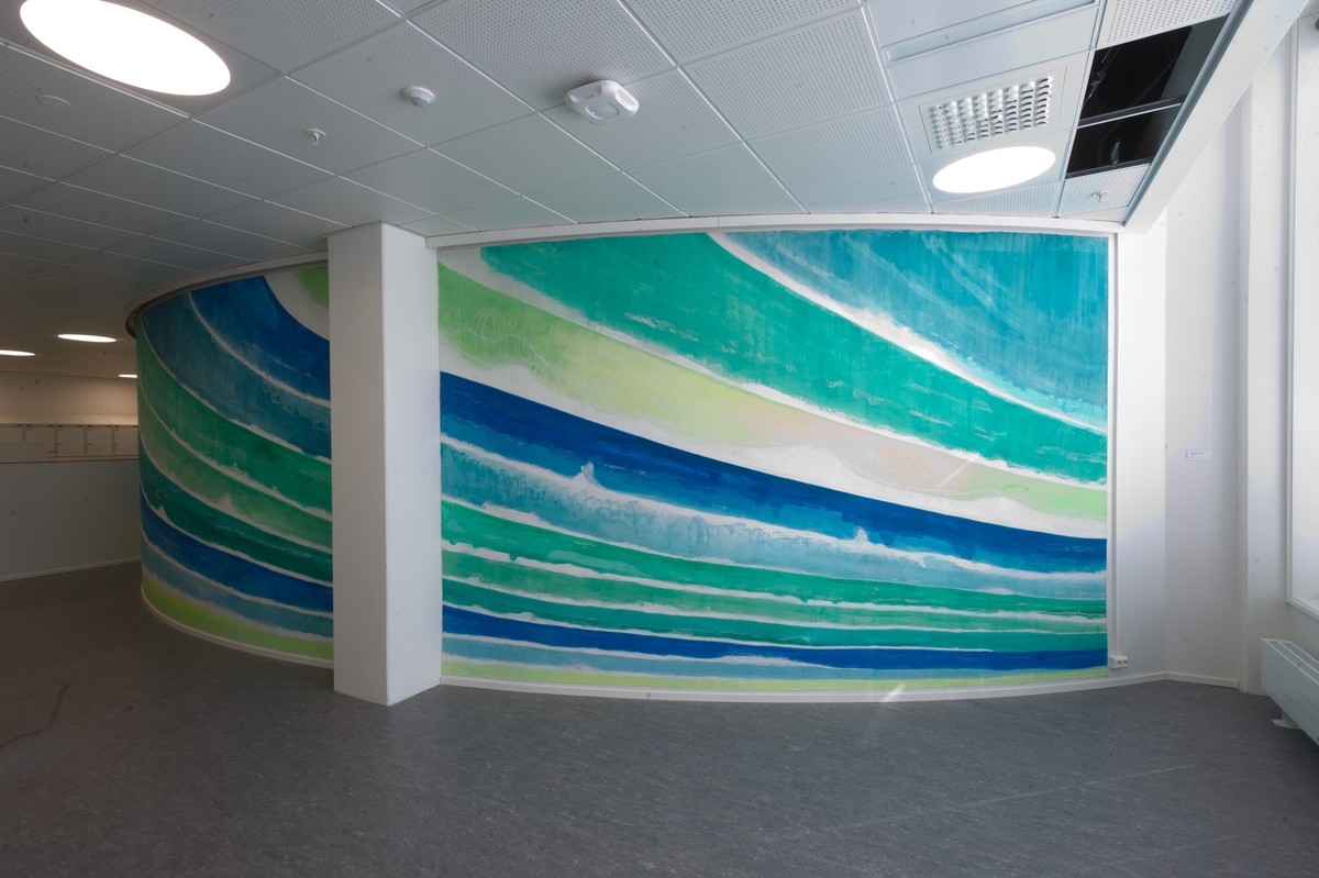 Maleriet viser abstraherte bølgeformer i grønt og blått som et heldekkende sceneteppe til bølgeteateret i simulatoren innenfor.