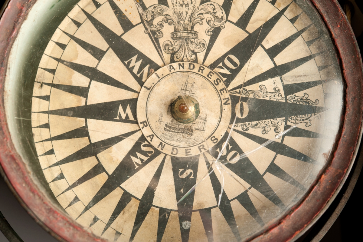 Kompass i skål av metall med glaslock och kardansk upphängning. Rosen indelad i hela streck. (Diameter avser rosen.)