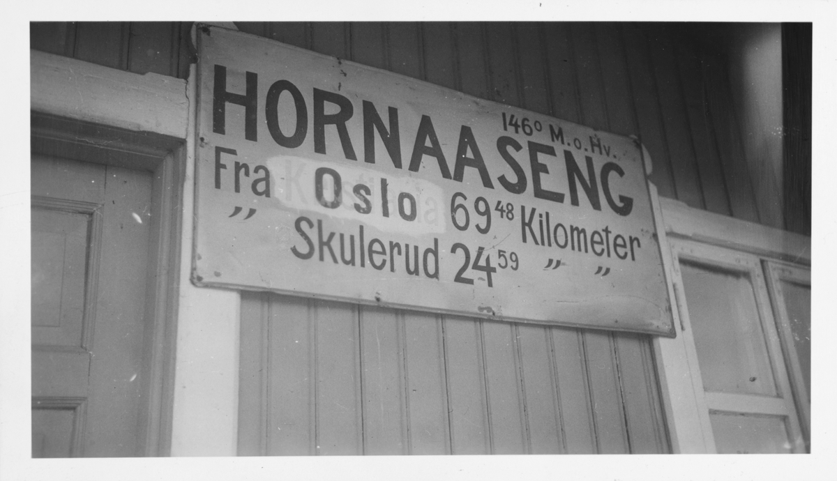 Stasjonsskiltet på Hornåseng stasjon fotografert i juni 1959. Stasjonsnavnet er ikke endret fra Hornaaseng. .