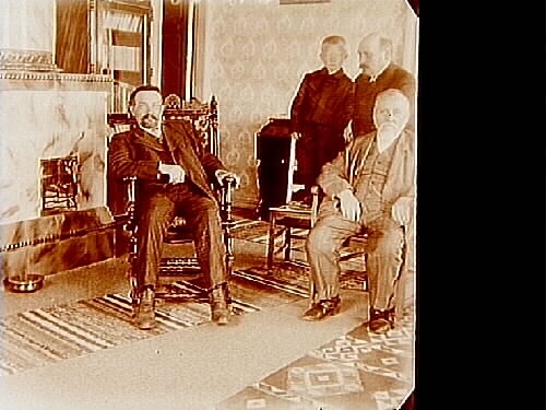 Familjebild, rumsinteriör, tre män och en pojke.
Två bilder (8x8 cm) på samma glasplåt (8x17 cm).