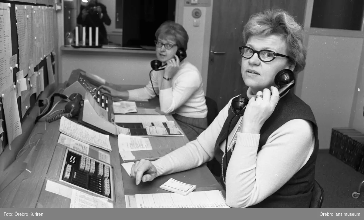 Växeltelefonister 31 januari 1969

Två kvinnor som arbetar i en telefonväxel. En kvinna i polotröja och kjol pratar i telefonen. Den andra kvinnan i polotröja och klänning håller telefonen mot kinden.