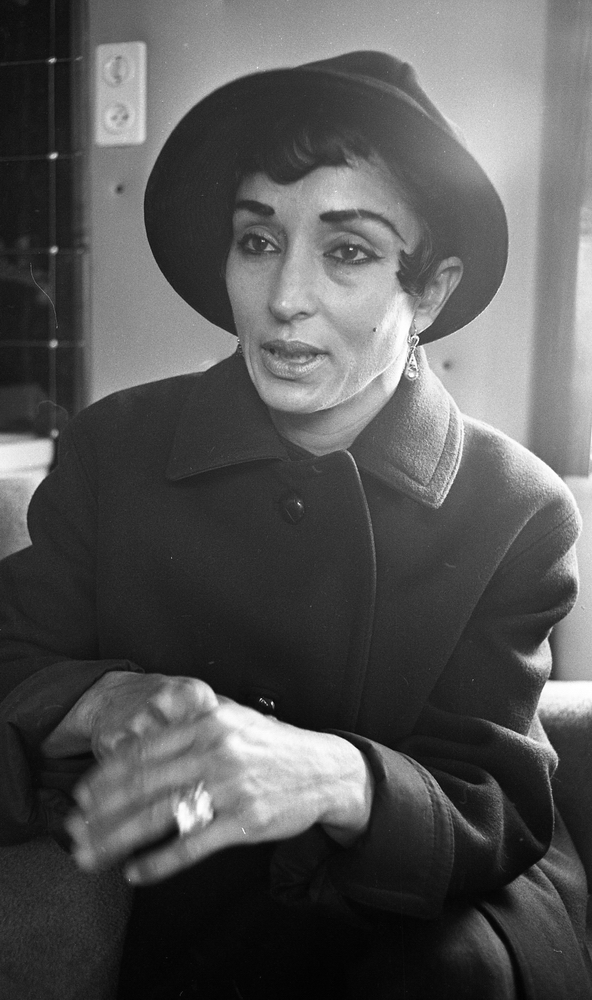 Miss Mara 18 maj 1967

Närbild på en mörkhårig dam som kallas "Miss Mara" och som är klädd i hatt och kappa. Hon bär örhängen och ring på fingret.