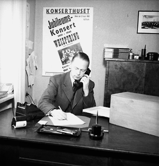 Kontorsinteriör, en man pratar i telefon.
Örebro Läns Musikförening.