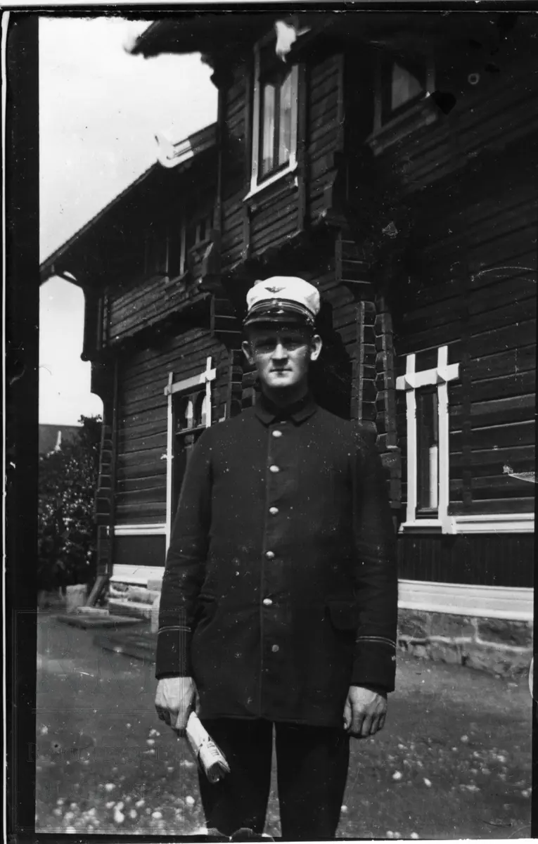 Telegrafist Ludvig Opsahl (1883-1960), stående i uniform utenfor en stasjon.