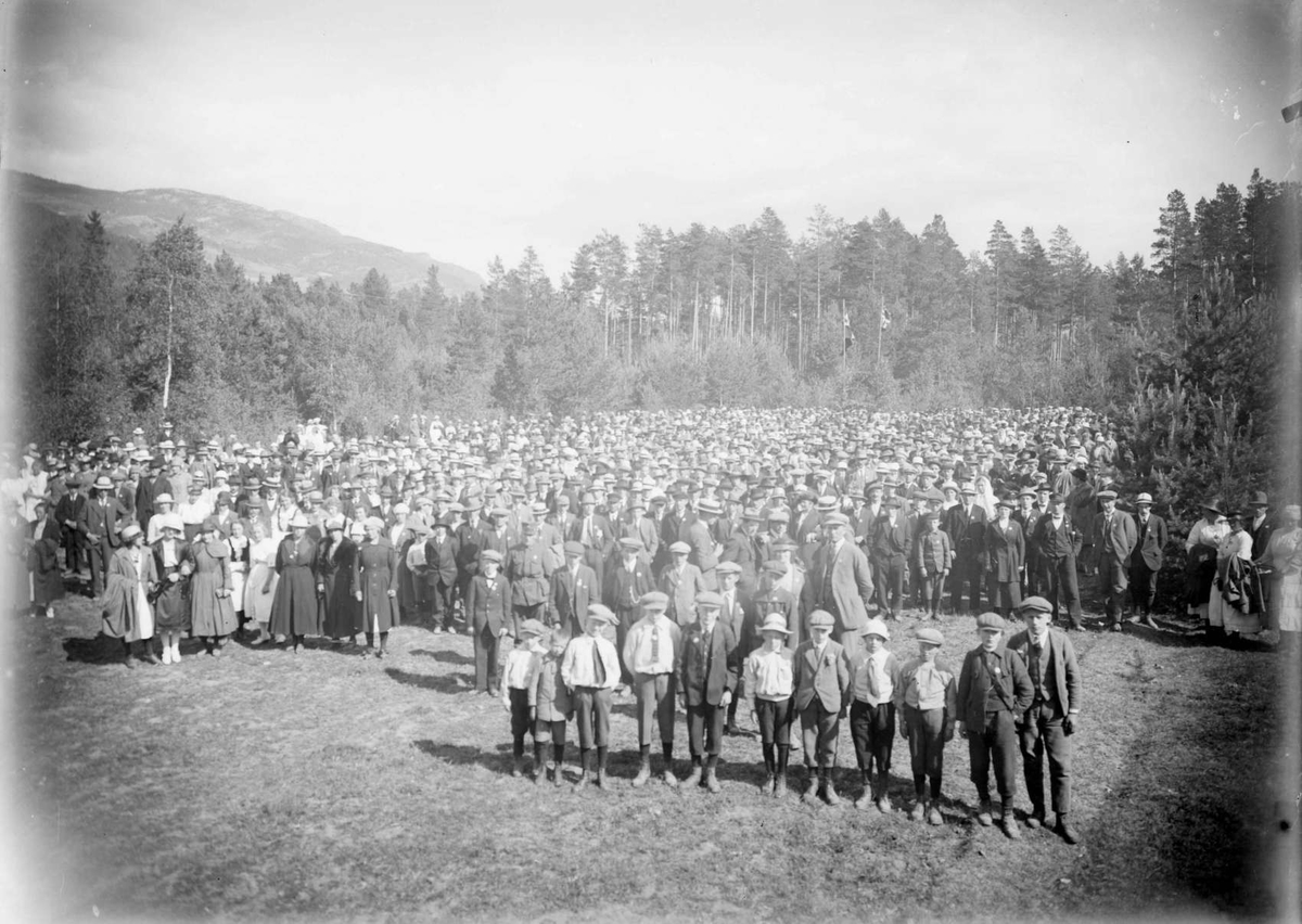 Mange mennesker - flere hundre, på åpen plass i skogen