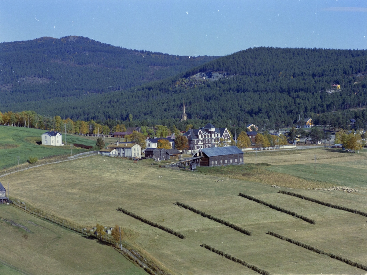 Flyfoto, tettsted, fra v. gårdsbruket Søre Dombås, nå også nevnt som Domaas nistugu,  og Dombås Turisthotell. Spiret til Dombås kirke skimtes bak i skogen.