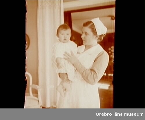 Rumsinteriör, en kvinna och en liten flicka.
Barnsköterskan Annie (Titti) Wallin och Barbro Thermaenius