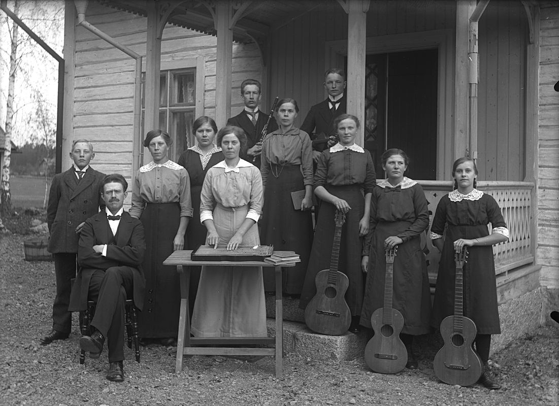Ullersäters församlings Musikförening, grupp framför byggnad.
Längst upp till vänster Johannes Natanael Bäckman.
Till höger Svea Falk (?) och Anna Andersson.