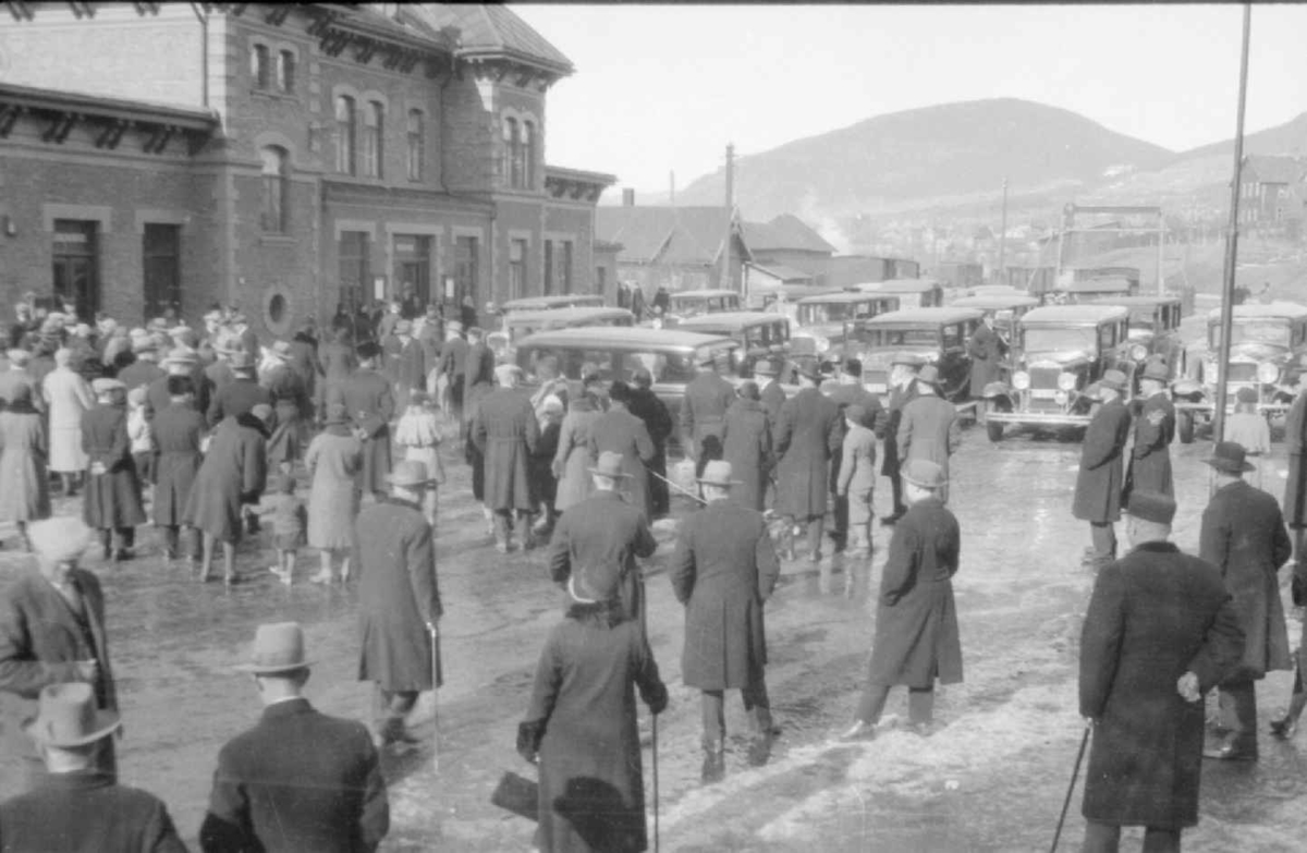 Lillehammer jernbanestasjon, mange menesker og biler  foran stasjonen, 1930-åra