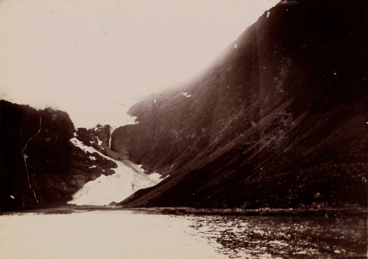 Fjord og et fjell med spor etter snøras.
