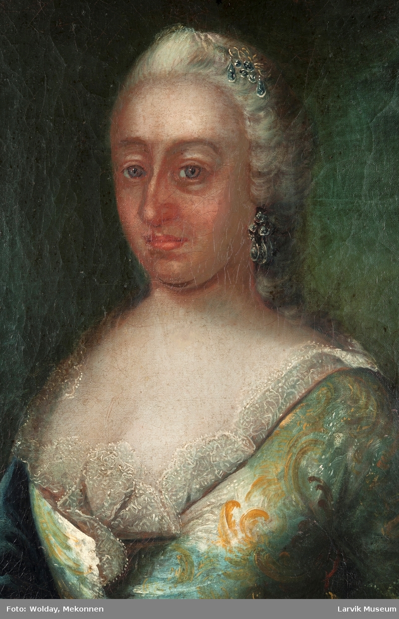 Portrett dame i grønn kjole m/gult mønster, hvit besetning i halsen, mørkegrønn kappe