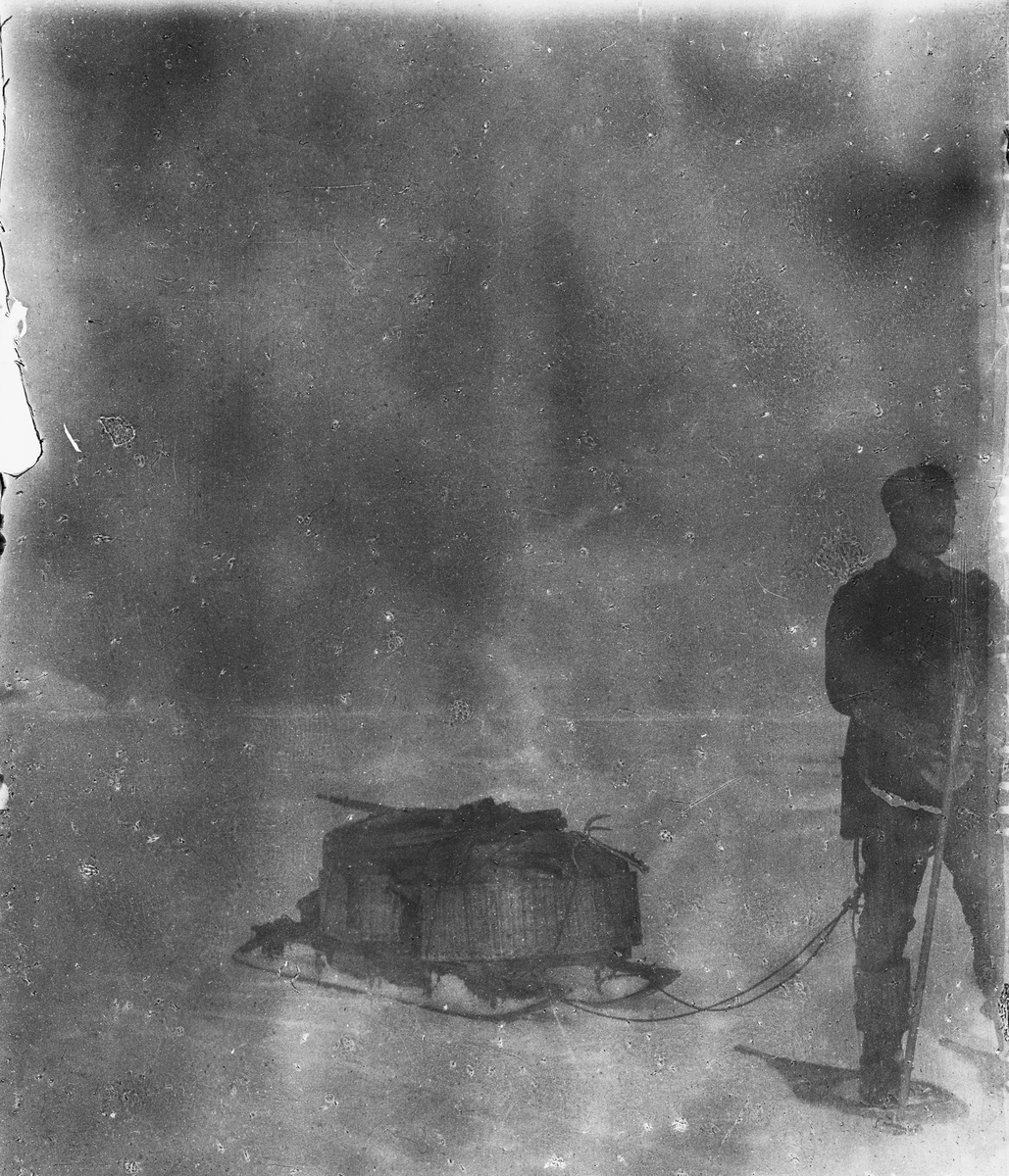 Nils Strindberg med lastad kälke under isvandandringen. Detta är enda tillfället då snöskorna syns i bruk. Framtagning av bilderna gjordes av docent John Hertzberg år 1930 på Fotografi, Tekniska Högskolan.