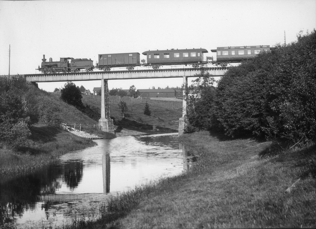 Diapositiv, fotografi över tåg på järnvägsbro över å (älv).