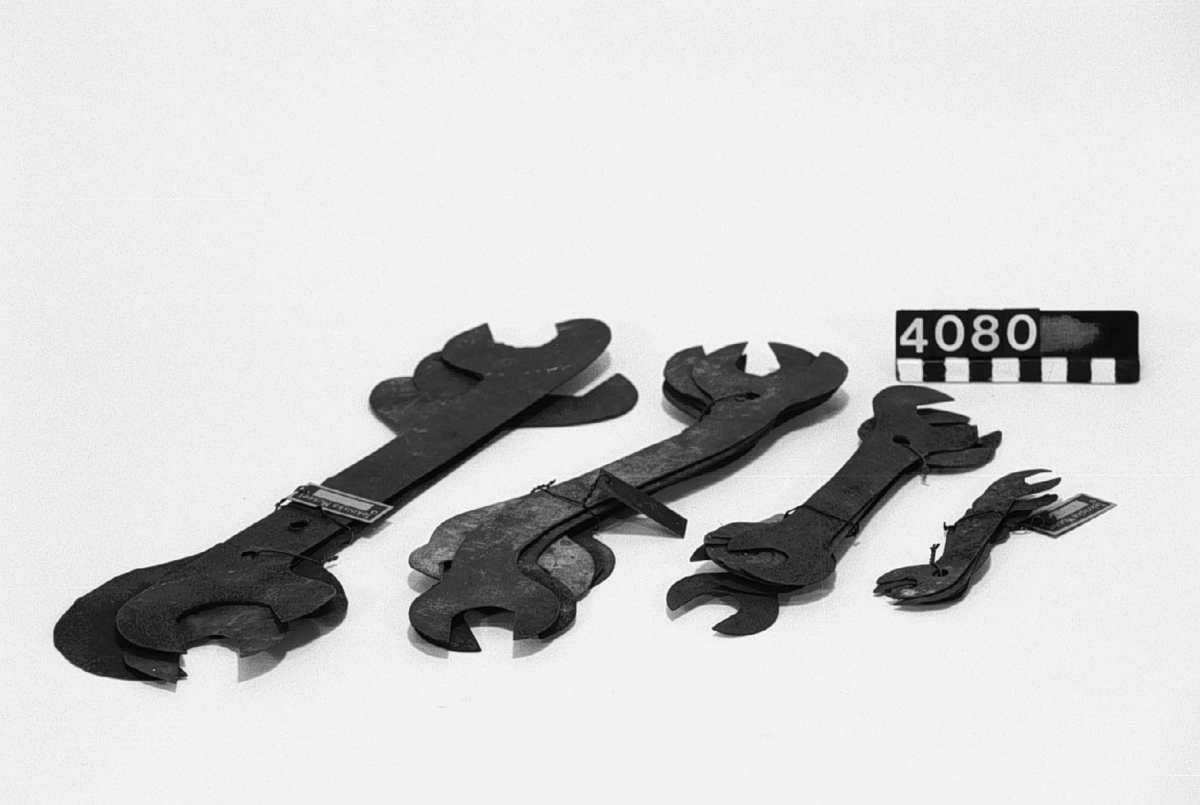En samling mallar av svartplåt och galvaniserad plåt, för tillverkning av fasta skruvnycklar i olika storlekar. Längd: 77-337 mm, bredd: 22-95 mm.