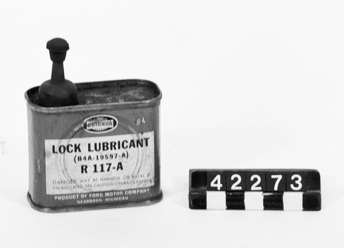 Plåtburk märkt: "Rotunda Lock Lubricant (B4A-19587-A) R 117-A. Product of Ford Motor Company Dearborn Michigan Innehåller 4 FL ozs 0,1183 litres. Container and contents made in USA RLL-41-D1".